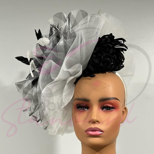 Black and white fascinator with a huge feather and a flower.